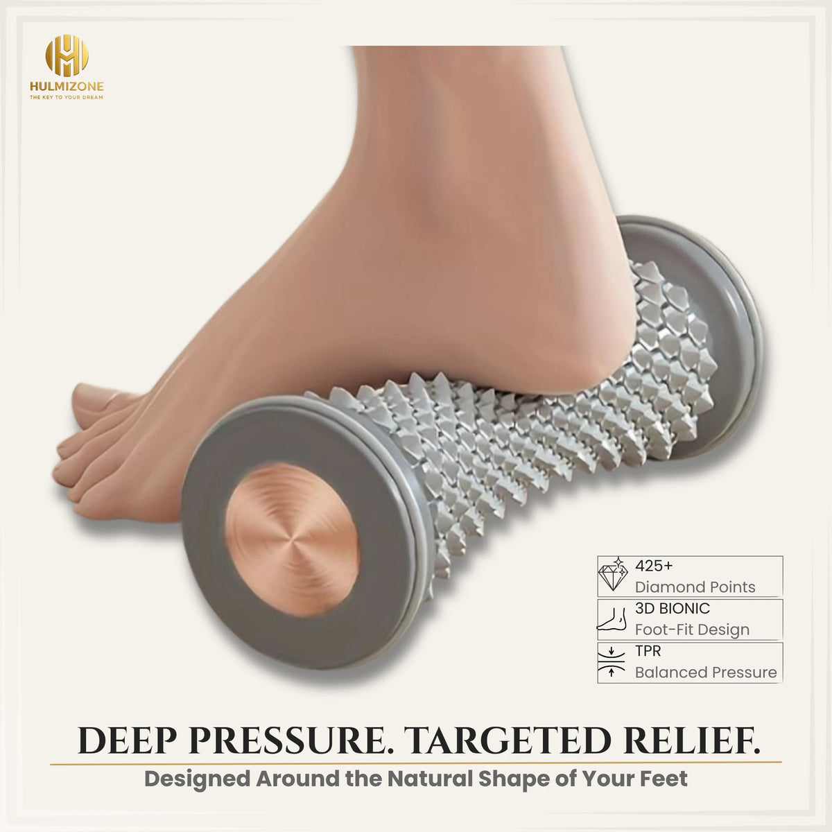 A close-up of a foot and lower leg pressing down on a textured, spiked foot roller massager. The product has gray circular ends with metallic rose-gold centers and a silver, spiky TPR foam body.